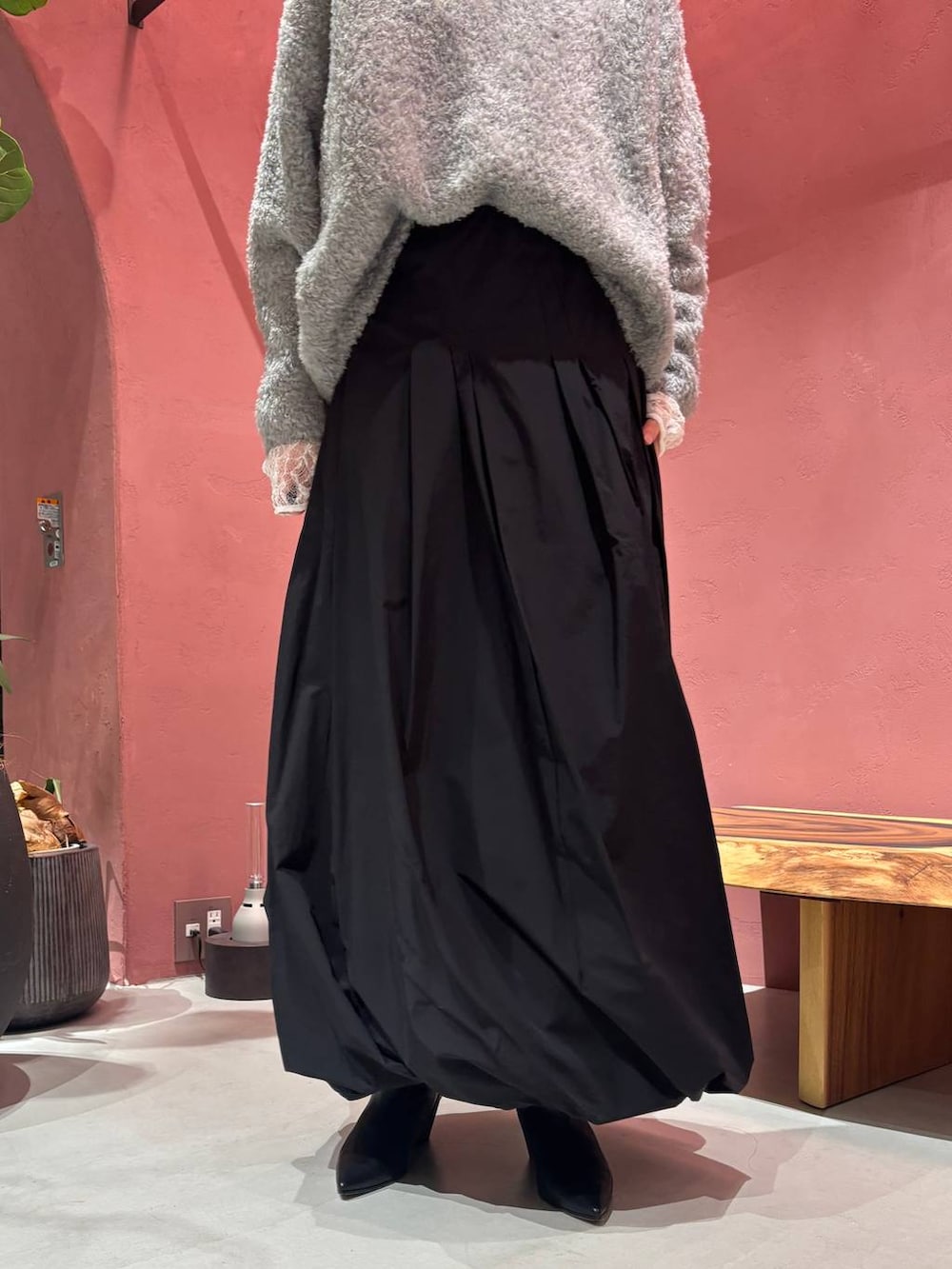 グレー系のニット/セーター、ホワイト系のTシャツ/カットソー、ブラック系のチェスターコートを着用したレディースの秋コーディネートの9枚目の写真