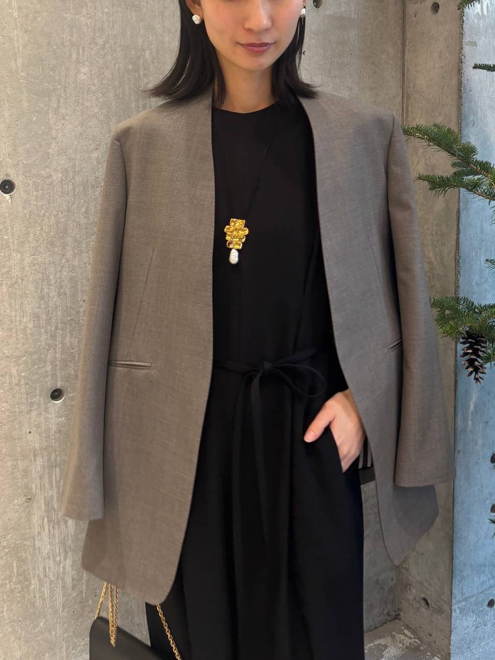 ベージュ系のノーカラージャケット、ブラック系のつなぎ/オールインワンを着用したレディースの冬コーディネートの6枚目の写真