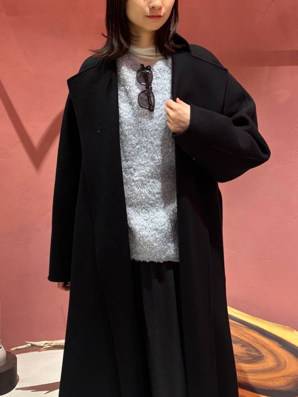 ブルー系のニット/セーター、ブラック系のノーカラーコート、ホワイト系のその他トップスを着用したレディースの秋コーディネートの3枚目の写真