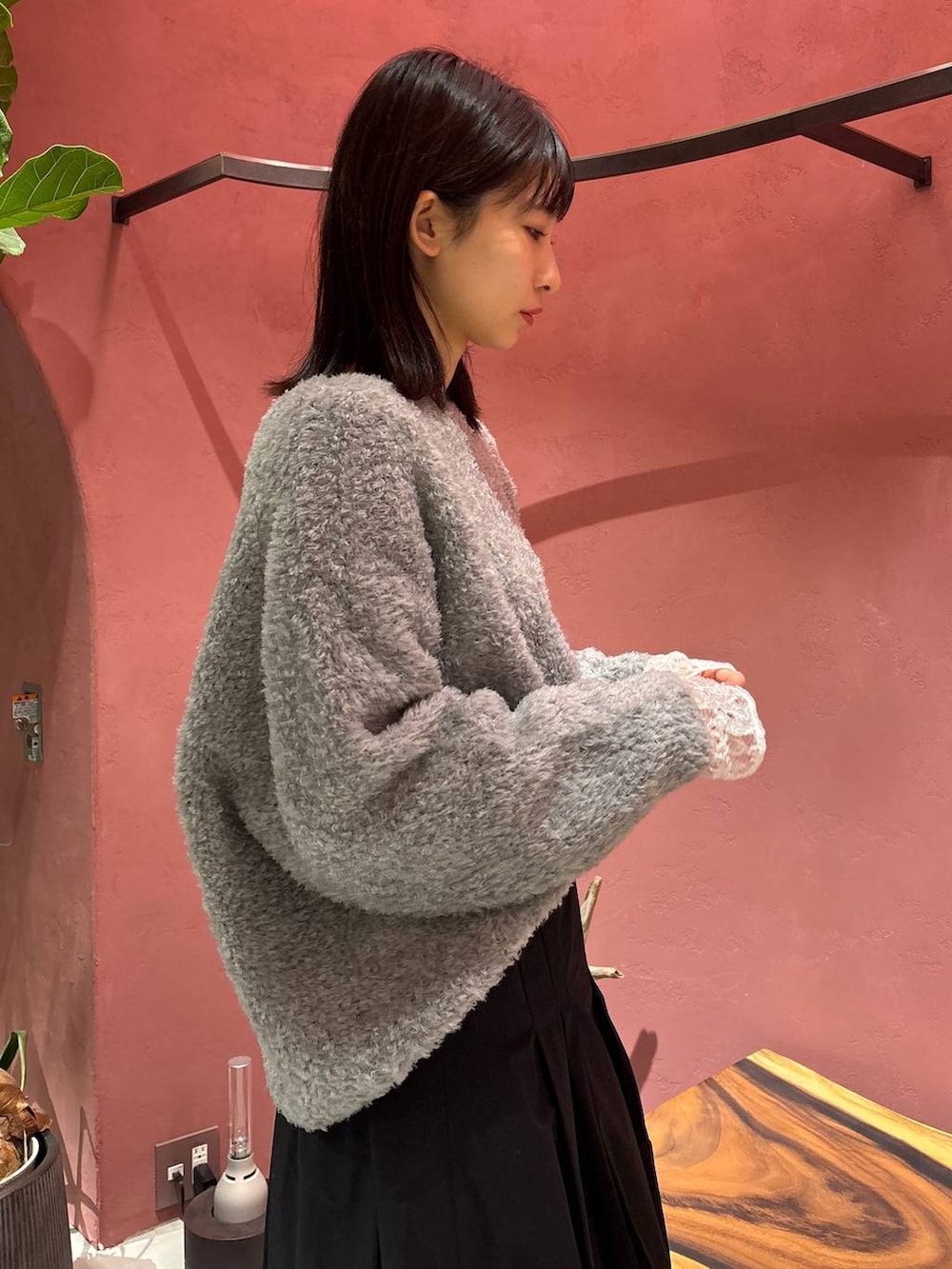 グレー系のニット/セーター、ホワイト系のTシャツ/カットソー、ブラック系のチェスターコートを着用したレディースの秋コーディネートの7枚目の写真