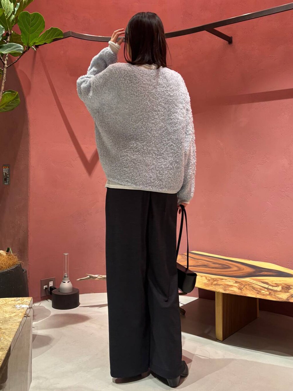 ブルー系のニット/セーター、ブラック系のノーカラーコート、ホワイト系のその他トップスを着用したレディースの秋コーディネートの6枚目の写真