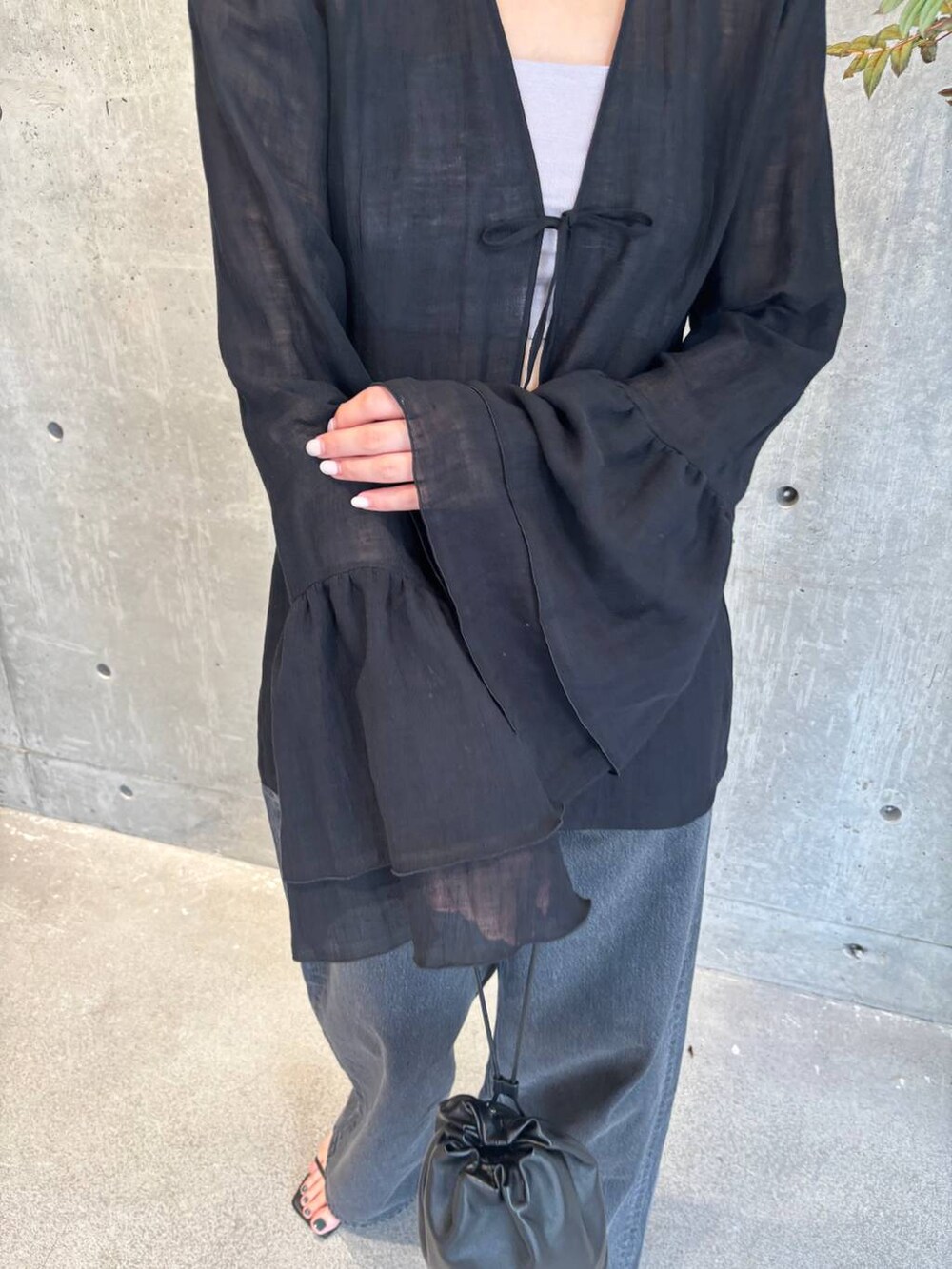 グレー系のチューブトップ、ブラック系のデニムパンツ、ブルー系のニット/セーターを着用したレディースの夏コーディネートの6枚目の写真