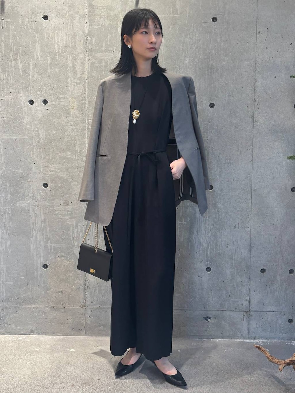 ベージュ系のノーカラージャケット、ブラック系のつなぎ/オールインワンを着用したレディースの冬コーディネートの2枚目の写真