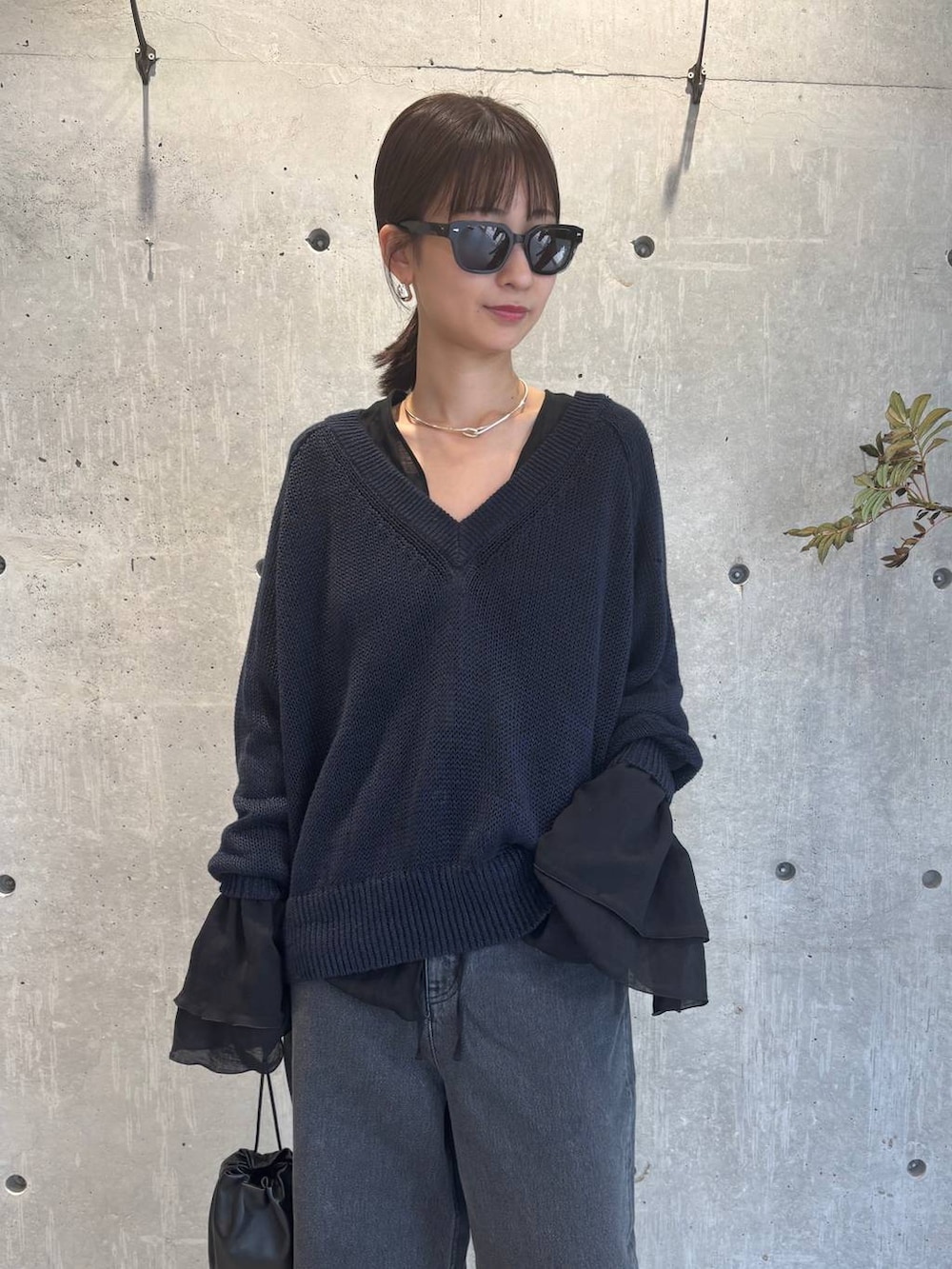 グレー系のチューブトップ、ブラック系のデニムパンツ、ブルー系のニット/セーターを着用したレディースの夏コーディネートの8枚目の写真