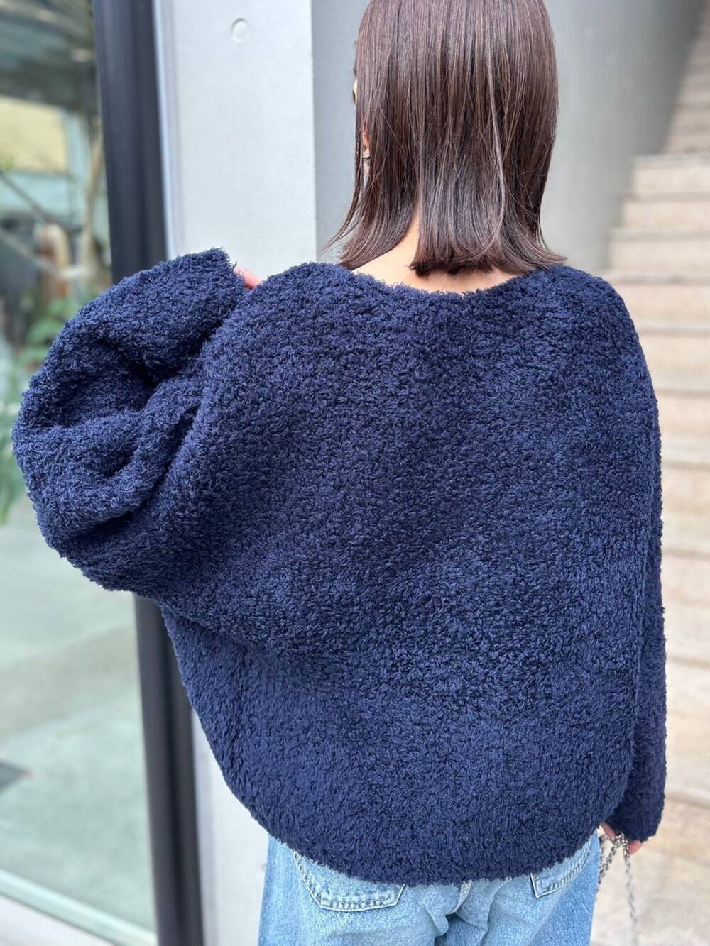 ブルー系のニット/セーター、ブルー系のデニムパンツ、ブルー系のその他アウターを着用したレディースの秋コーディネートの9枚目の写真