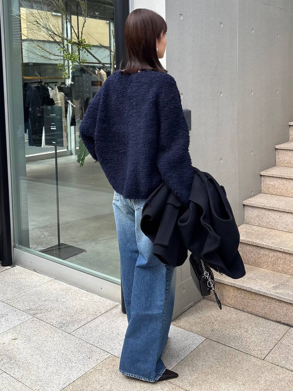 ブルー系のニット/セーター、ブルー系のデニムパンツ、ブルー系のその他アウターを着用したレディースの秋コーディネートの5枚目の写真