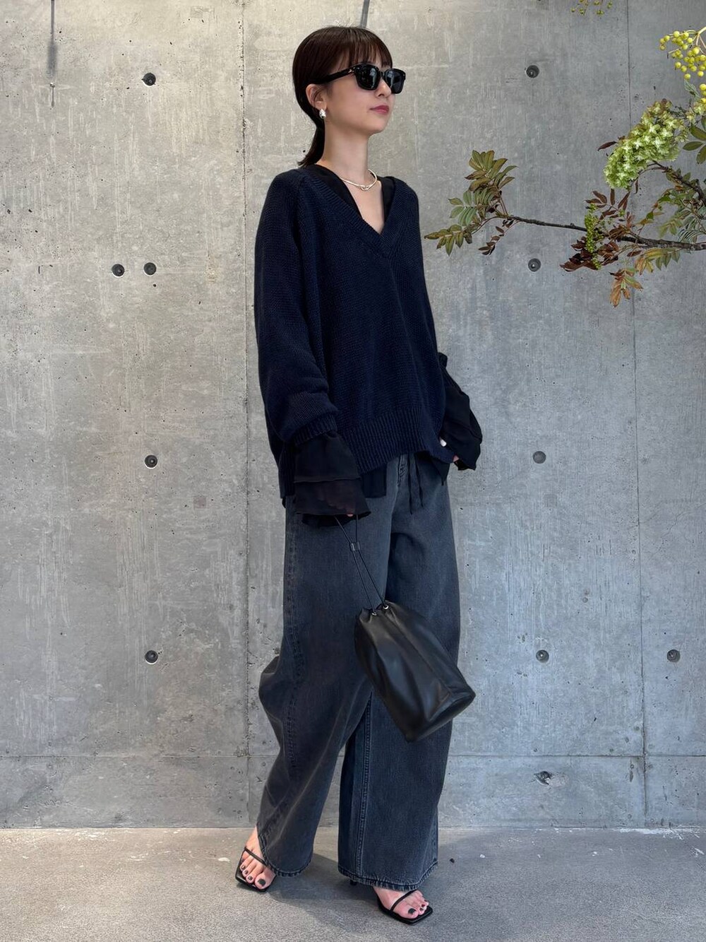 グレー系のチューブトップ、ブラック系のデニムパンツ、ブルー系のニット/セーターを着用したレディースの夏コーディネートの5枚目の写真