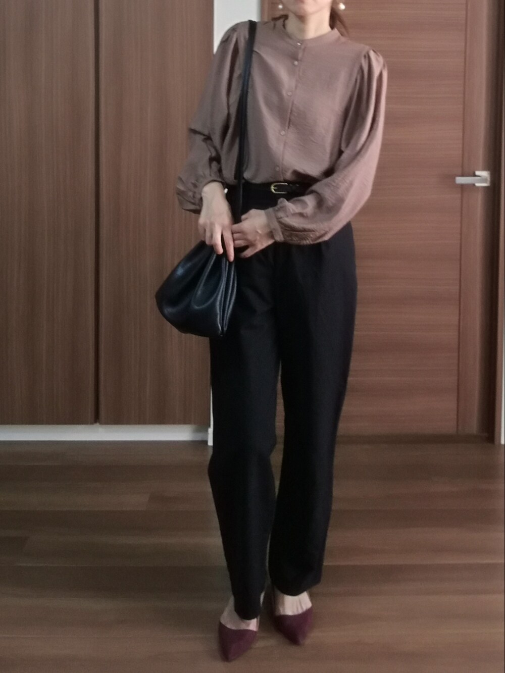 ブラウン系のシャツ/ブラウス、ブラック系のパンツを着用したレディースの秋コーディネートの3枚目の写真