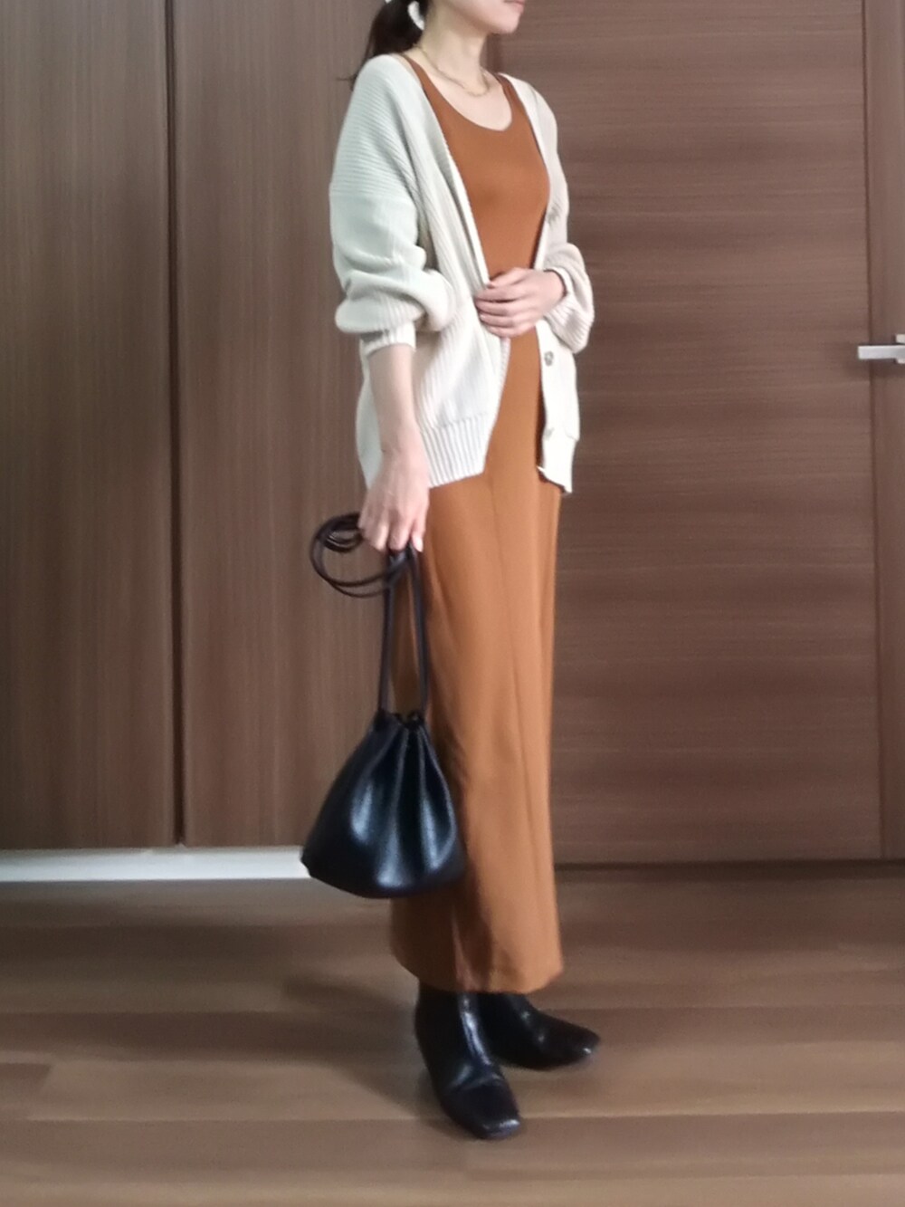 ブラウン系のタンクトップ、ベージュ系のカーディガン/ボレロ、オレンジ系のスカートを着用したレディースの秋コーディネートの2枚目の写真