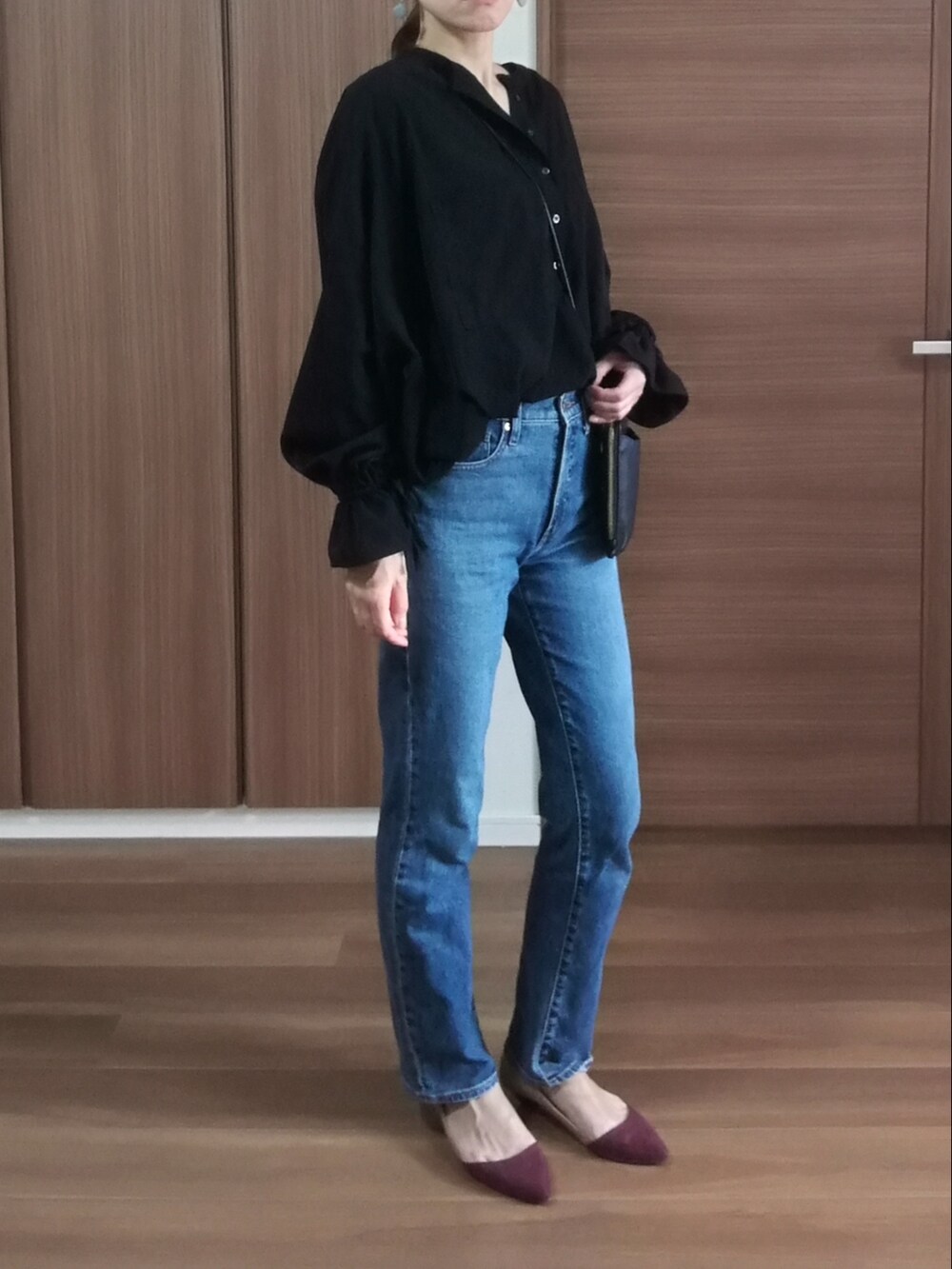 ブルー系のデニムパンツ、ブラック系のショルダーバッグ、ブラック系のシャツ/ブラウスを着用したレディースの秋コーディネートの2枚目の写真