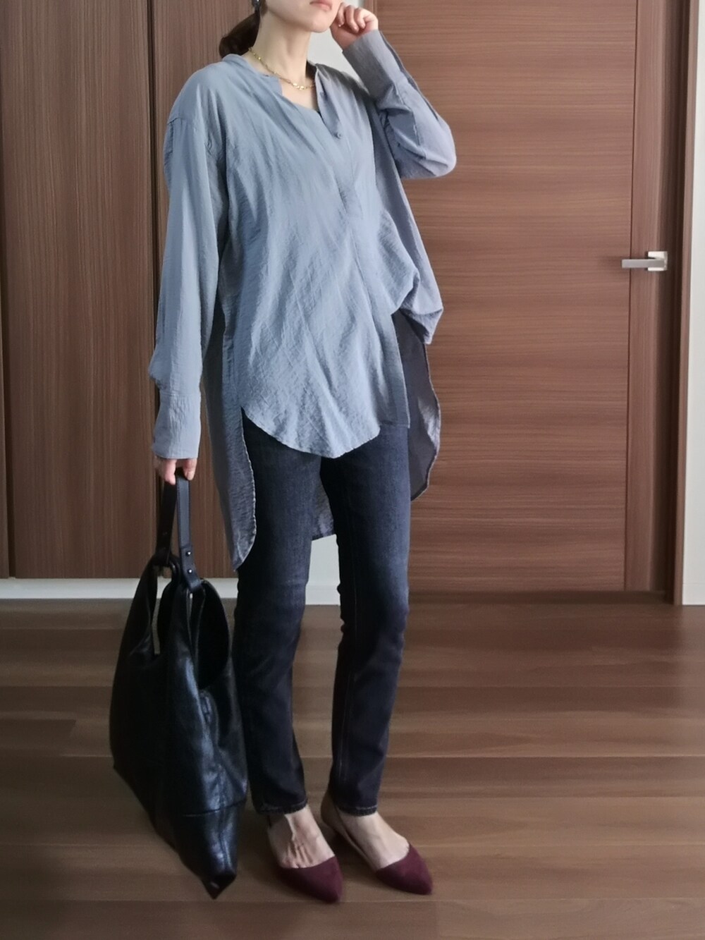 グレー系のデニムパンツ、ブラック系のショルダーバッグ、ブルー系のシャツ/ブラウスを着用したレディースの秋コーディネートの2枚目の写真