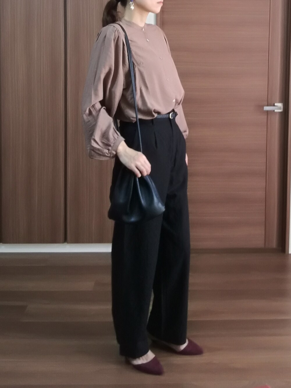 ブラウン系のシャツ/ブラウス、ブラック系のパンツを着用したレディースの秋コーディネートの2枚目の写真