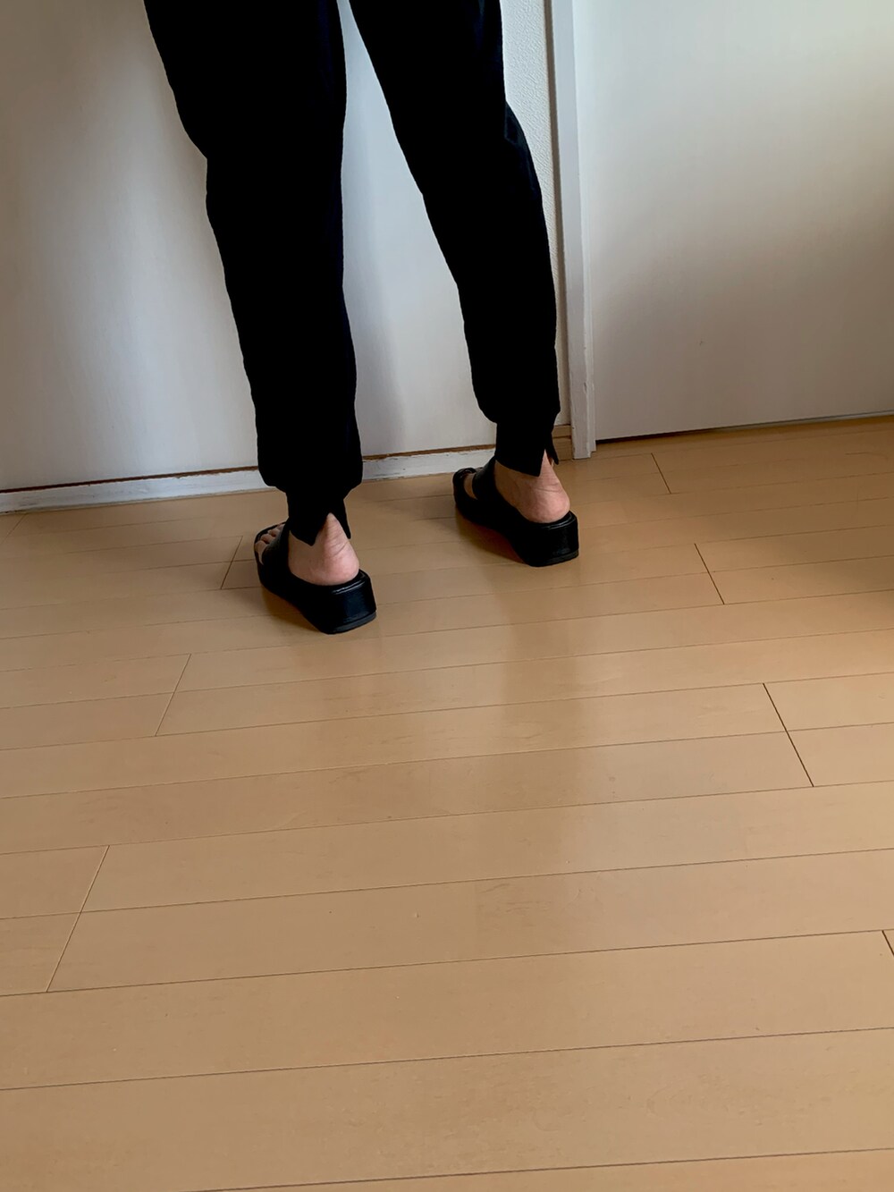 ブラック系のTシャツ/カットソー、ブラック系のスウェットパンツ、ブラック系のサンダルを着用したレディースの夏コーディネートの2枚目の写真