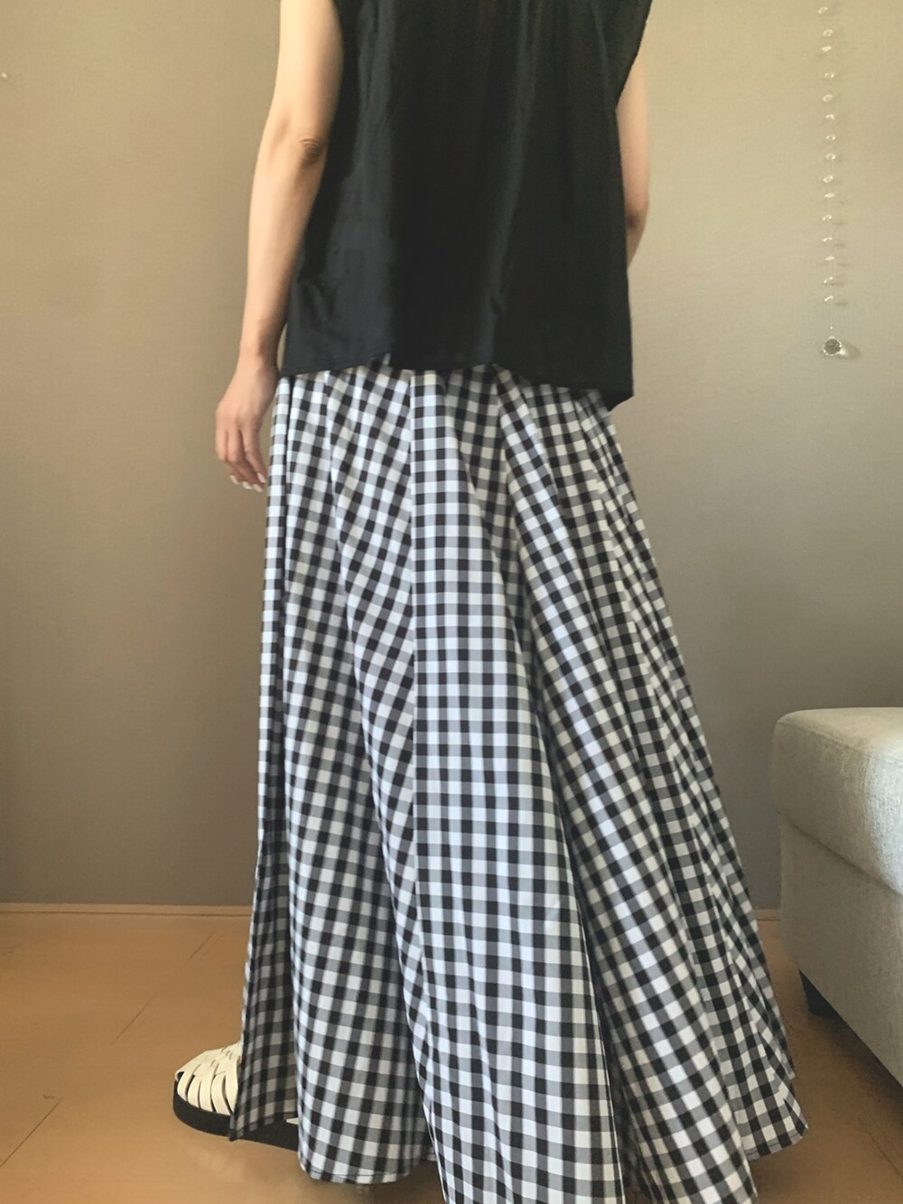 ブラック系のシャツ/ブラウス、ブラック系のスカート、ベージュ系のかごバッグを着用したレディースの夏コーディネートの2枚目の写真