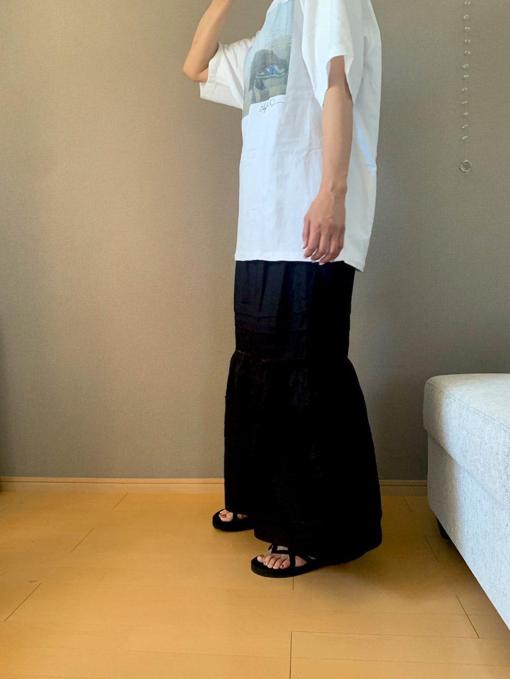 ホワイト系のTシャツ/カットソー、ブラック系のスカート、ブラック系のサンダルを着用したレディースの夏コーディネートの2枚目の写真