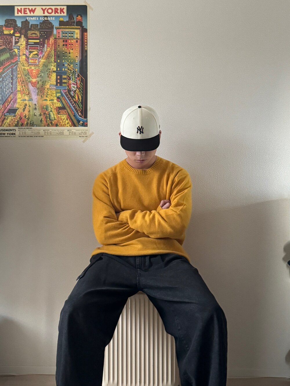 イエロー系のニット/セーター、ブラック系のデニムパンツ、ホワイト系のスニーカーを着用したメンズの冬コーディネートの4枚目の写真