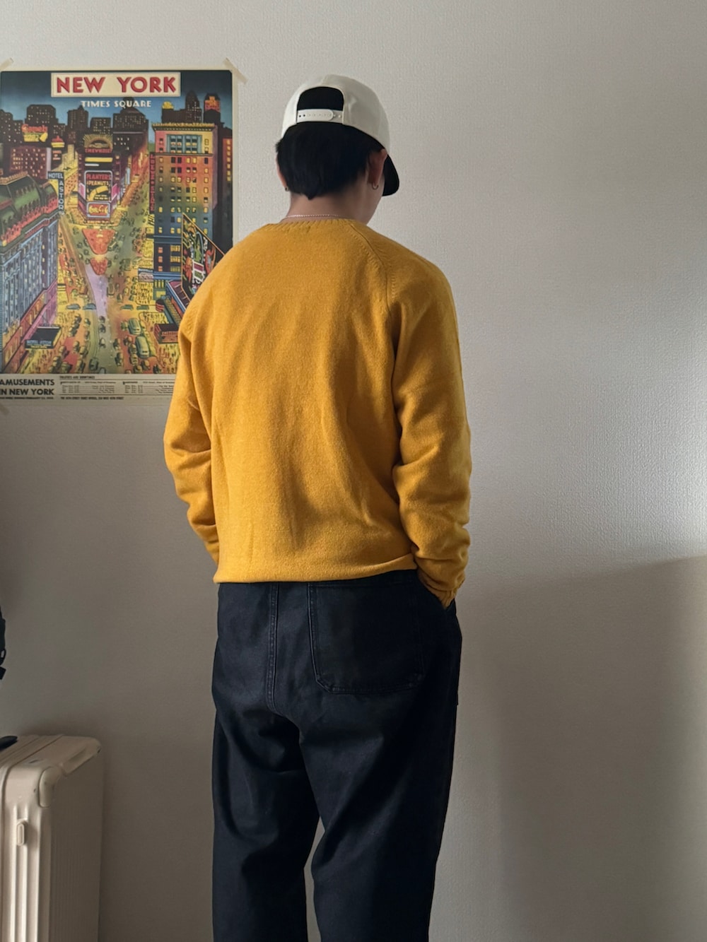 イエロー系のニット/セーター、ブラック系のデニムパンツ、ホワイト系のスニーカーを着用したメンズの冬コーディネートの5枚目の写真