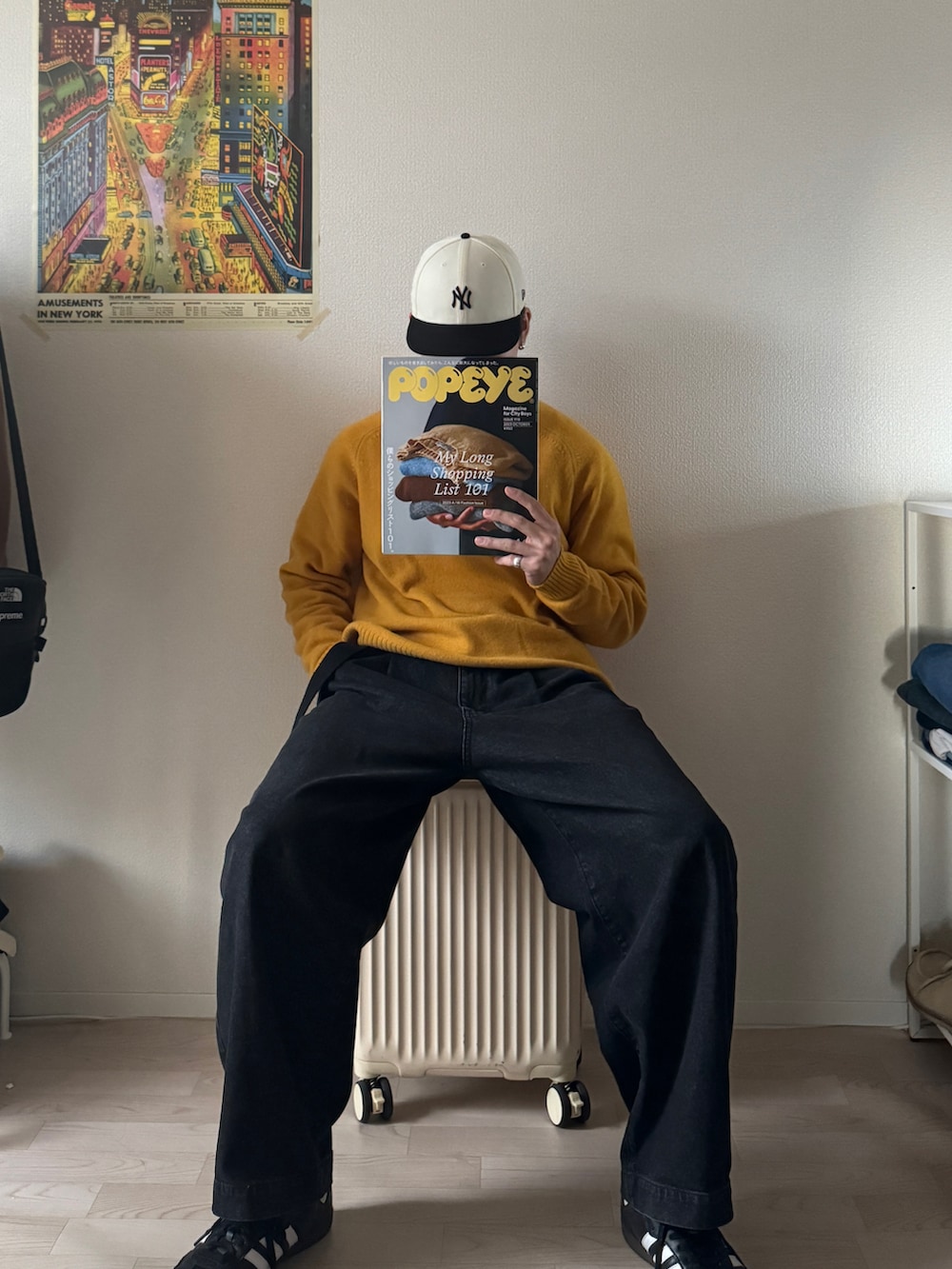 イエロー系のニット/セーター、ブラック系のデニムパンツ、ホワイト系のスニーカーを着用したメンズの冬コーディネートの2枚目の写真