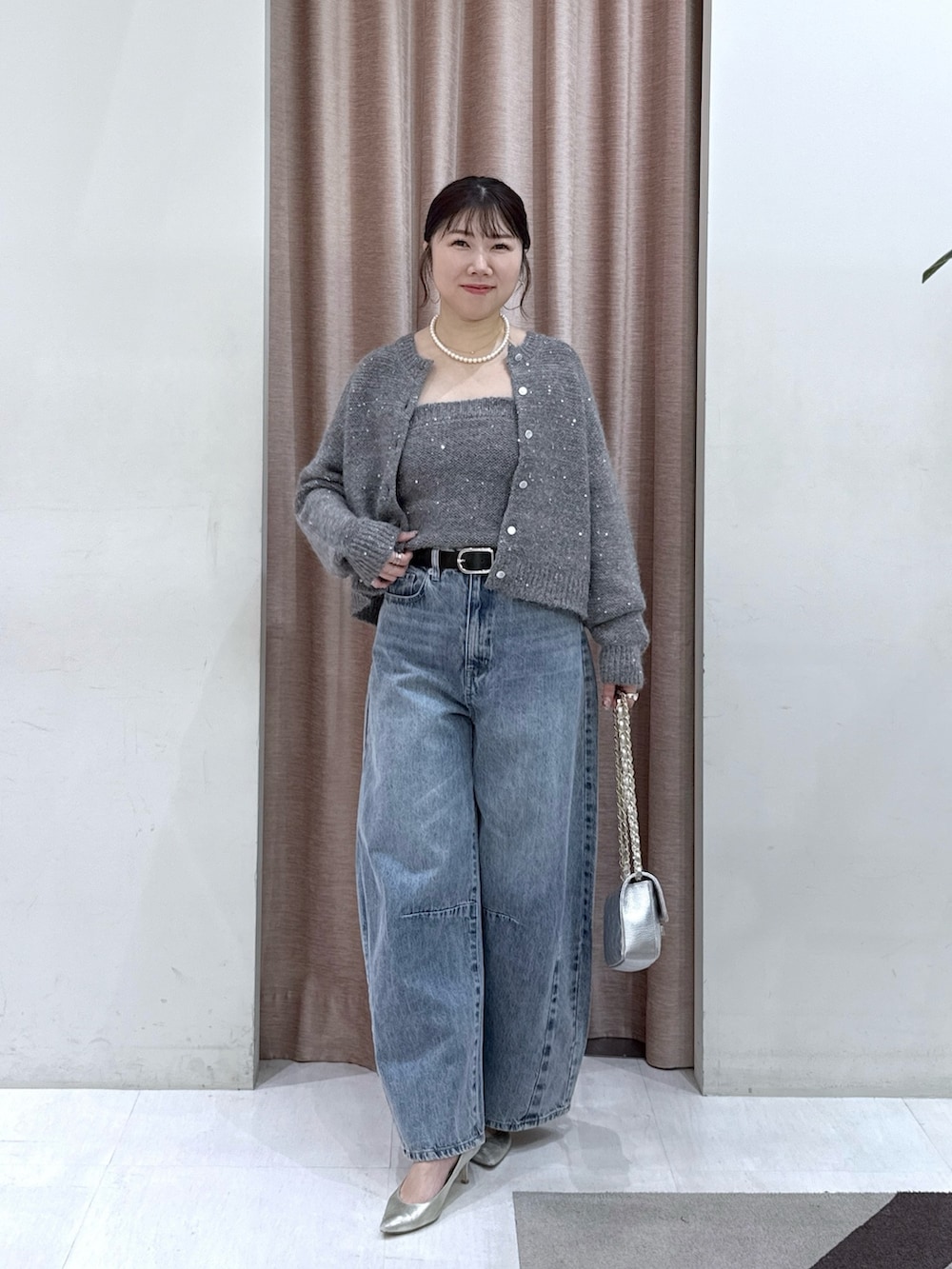 グレー系のカーディガン/ボレロ、グレー系のチューブトップ、ブルー系のデニムパンツを着用したレディースの秋コーディネートの5枚目の写真