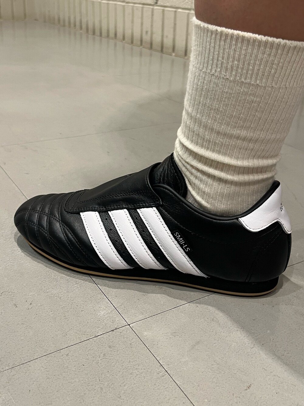 オレンジ系のパーカー、ブラック系のシューズを着用したレディースの秋コーディネートの4枚目の写真