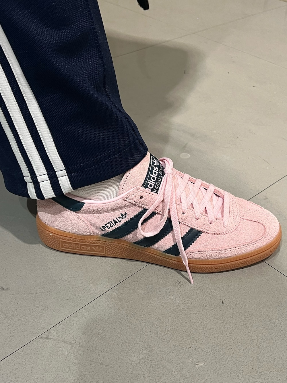 ブルー系のスウェットパンツ、シルバー系のハンドバッグ、ピンク系のスニーカーを着用したレディースの冬コーディネートの4枚目の写真