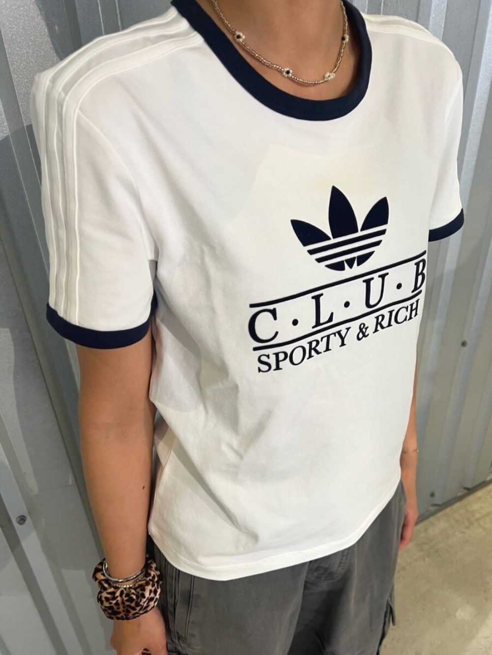 グリーン系のシューズ、ホワイト系のトップス、ブラック系のカーゴパンツを着用したレディースの夏コーディネートの2枚目の写真