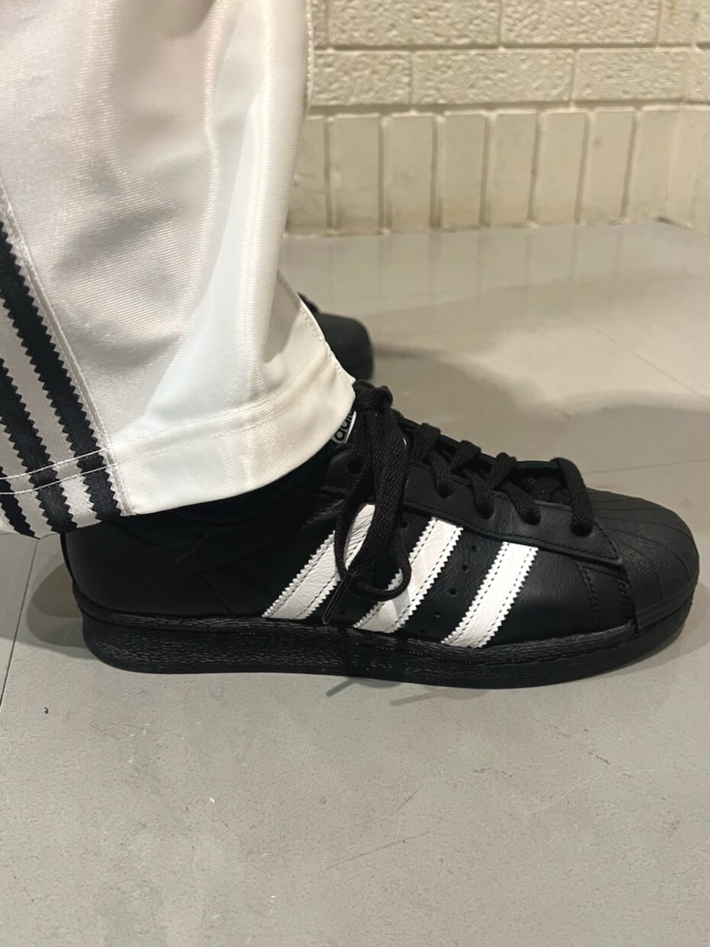 ブラック系のシューズ、ホワイト系のTシャツ/カットソー、シルバー系のハンドバッグを着用したレディースの春コーディネートの4枚目の写真