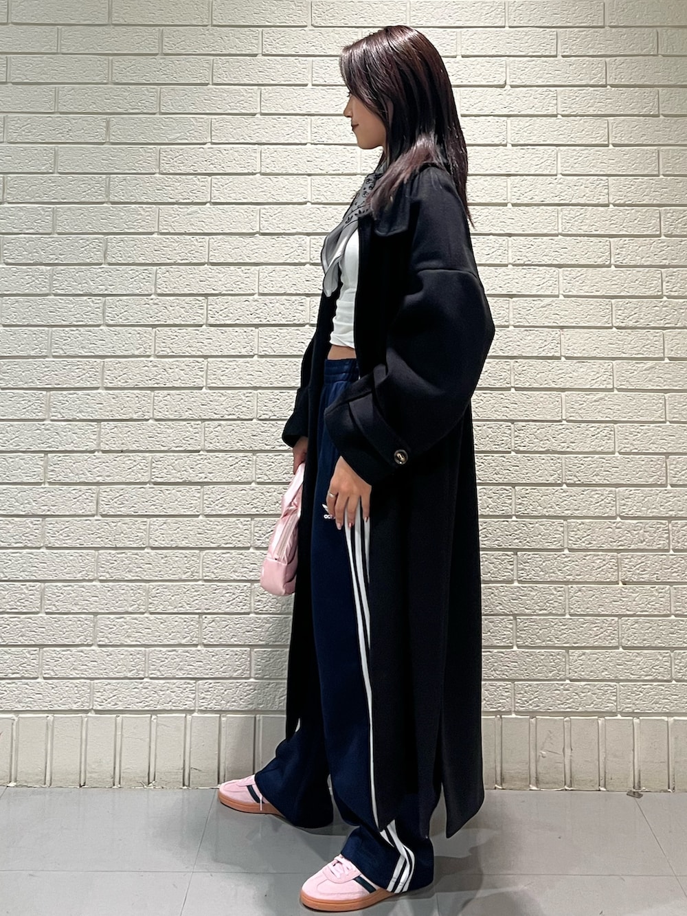 ブルー系のスウェットパンツ、シルバー系のハンドバッグ、ピンク系のスニーカーを着用したレディースの冬コーディネートの2枚目の写真