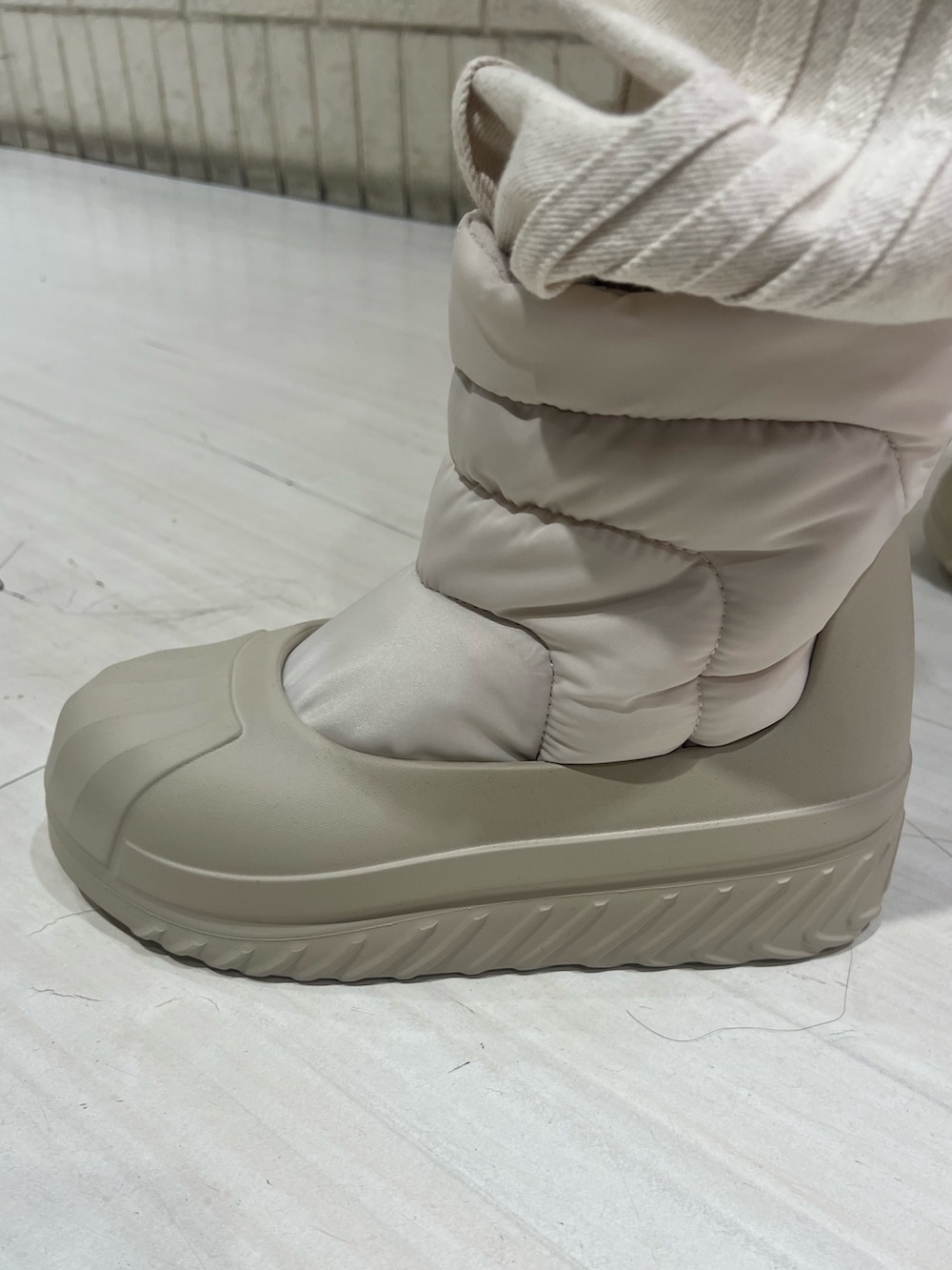 ベージュ系のジャージ、ホワイト系のデニムパンツ、ベージュ系のスニーカーを着用したレディースの秋コーディネートの4枚目の写真