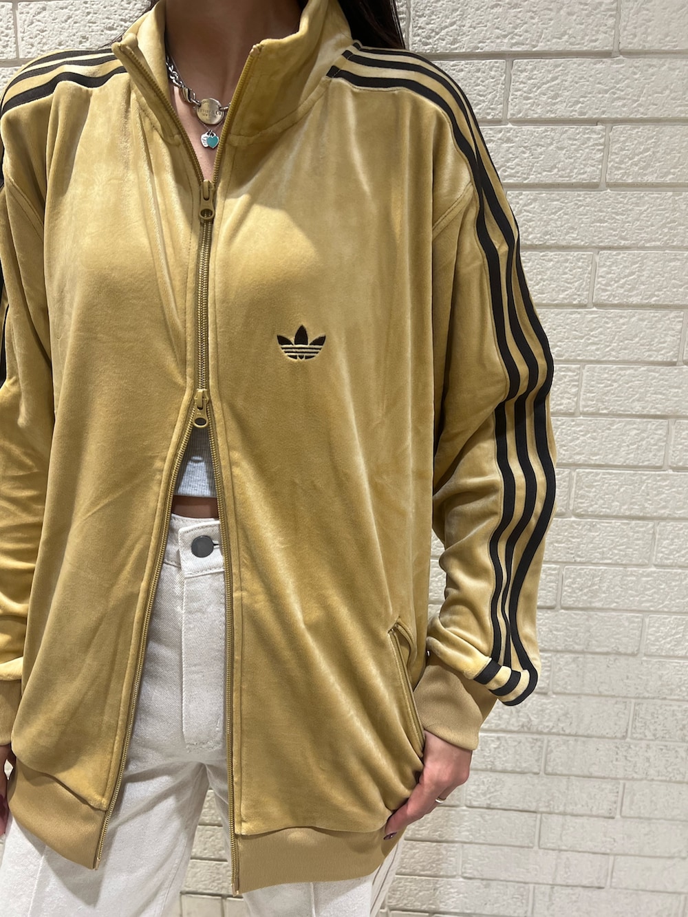 ベージュ系のジャージ、ホワイト系のデニムパンツ、ベージュ系のスニーカーを着用したレディースの秋コーディネートの3枚目の写真