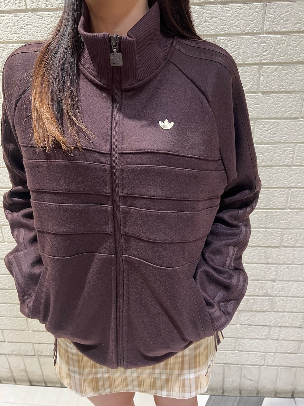 ブラウン系のジャージ、ベージュ系のスカート、ホワイト系のシューズを着用したレディースの秋コーディネートの3枚目の写真