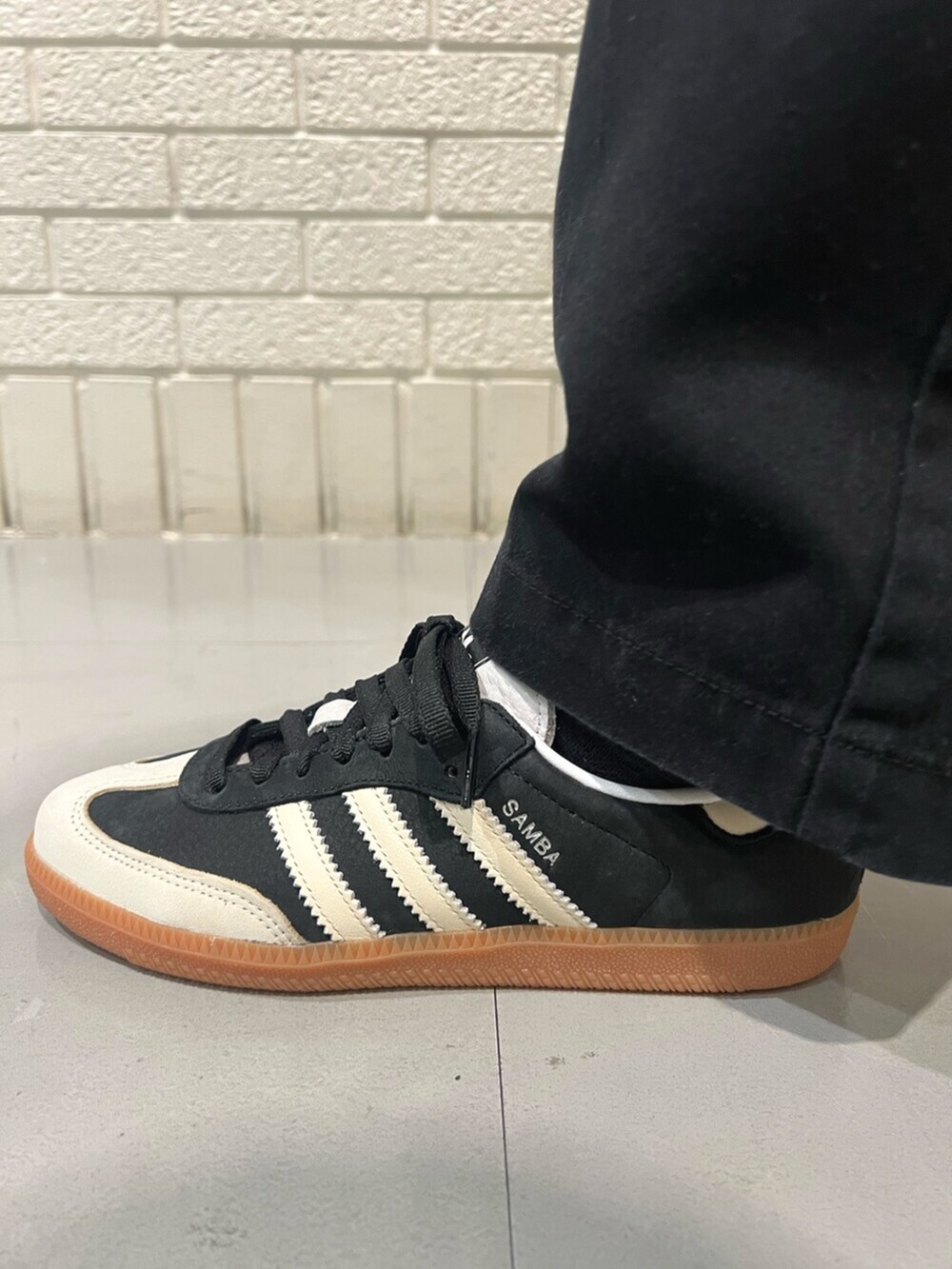 ホワイト系のTシャツ/カットソー、ブラック系のショルダーバッグ、ブラック系のスニーカーを着用したレディースの春コーディネートの4枚目の写真