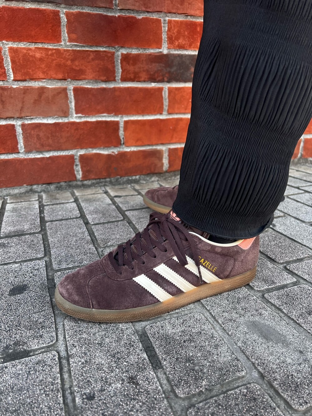 ブラック系のショルダーバッグ、ブラウン系のスニーカー、ブラック系のジャージを着用したレディースの春コーディネートの6枚目の写真