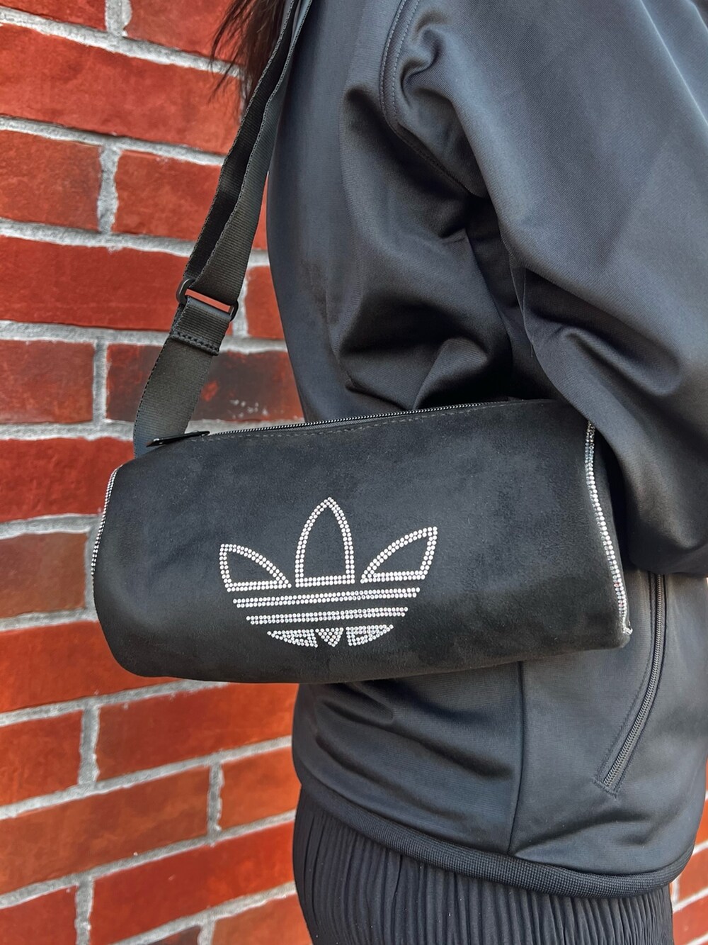 ブラック系のショルダーバッグ、ブラウン系のスニーカー、ブラック系のジャージを着用したレディースの春コーディネートの7枚目の写真