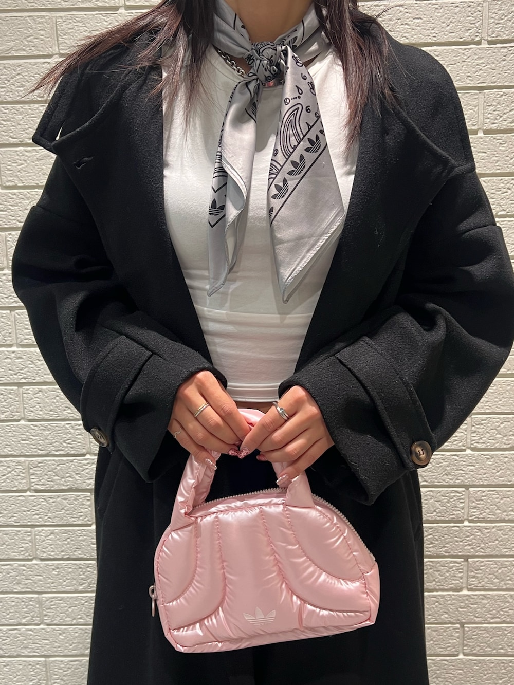 ブルー系のスウェットパンツ、シルバー系のハンドバッグ、ピンク系のスニーカーを着用したレディースの冬コーディネートの3枚目の写真