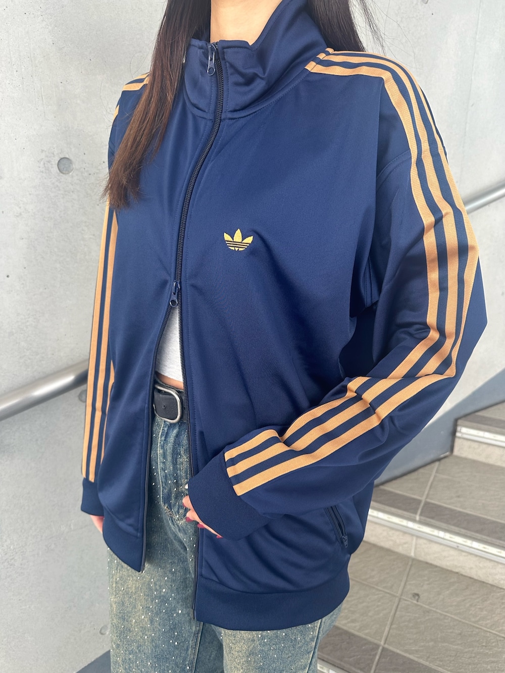 ブルー系のジャージ、ブラウン系のスニーカーを着用したレディースの秋コーディネートの2枚目の写真