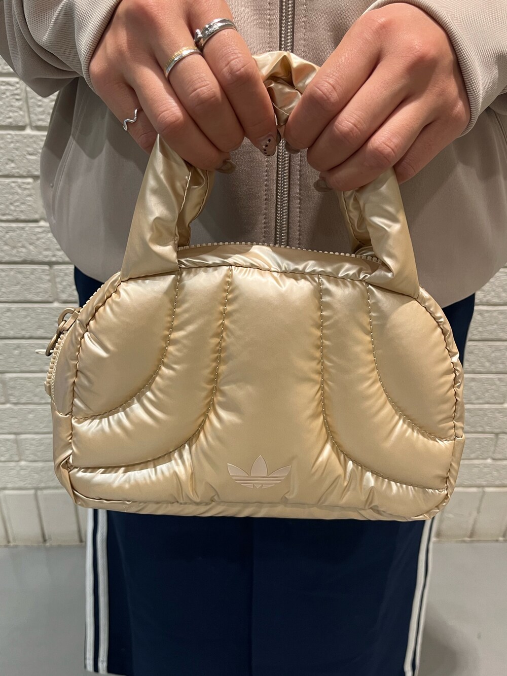 ベージュ系のジャージ、ブルー系のスカート、ベージュ系のスニーカーを着用したレディースの秋コーディネートの4枚目の写真