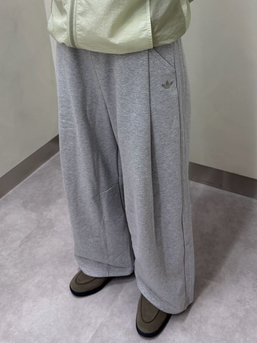 ブラウン系のスニーカー、グレー系のその他パンツを着用したレディースの秋コーディネートの3枚目の写真