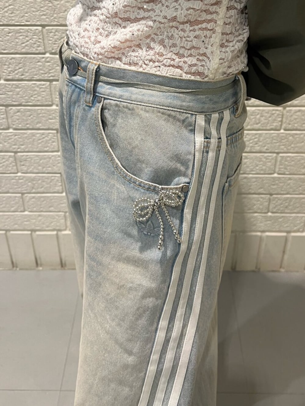 ブラック系のシューズアクセサリー、ブルー系のデニムパンツ、ホワイト系のスニーカーを着用したレディースの冬コーディネートの3枚目の写真