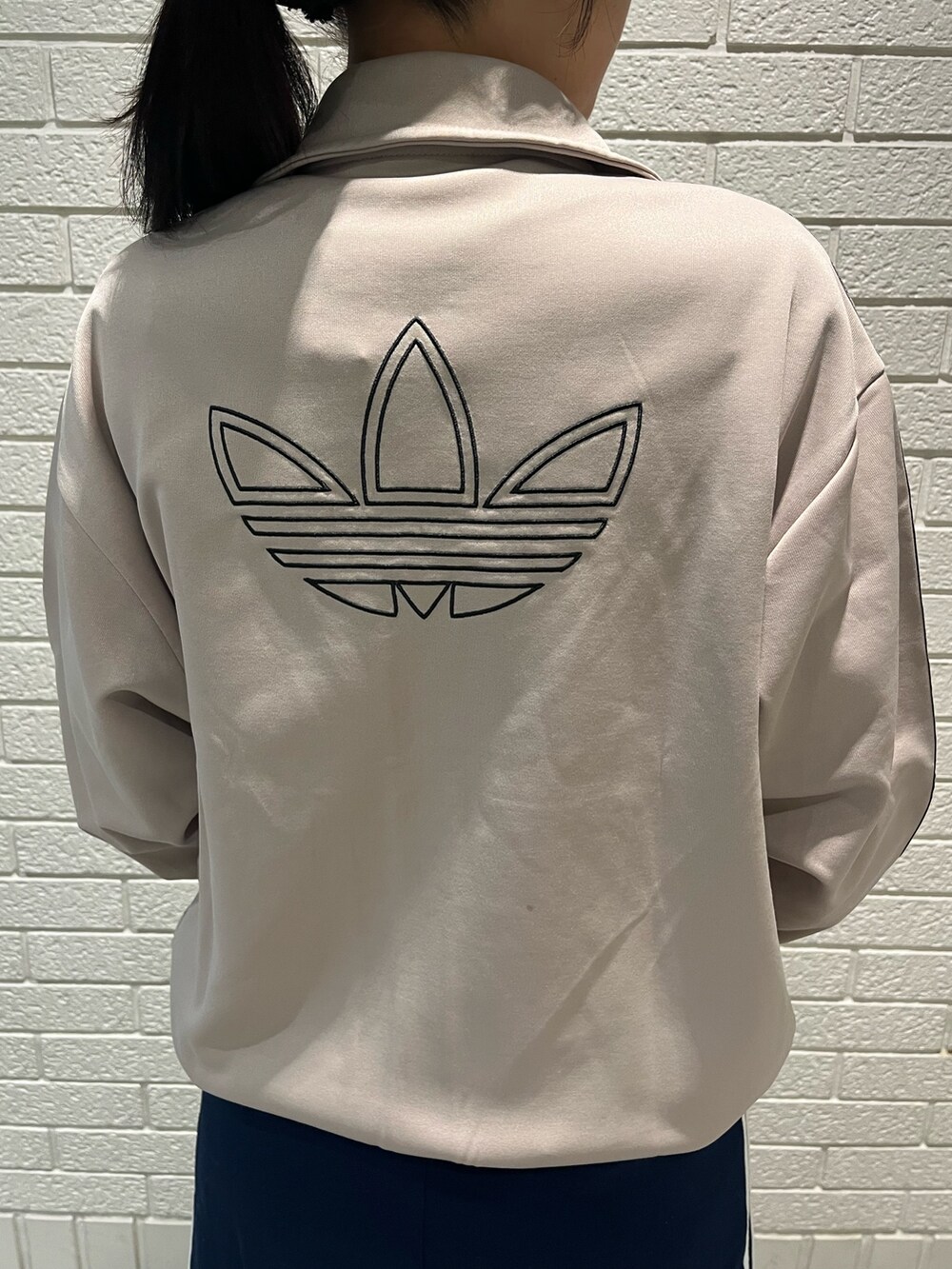 ベージュ系のジャージ、ブルー系のスカート、ベージュ系のスニーカーを着用したレディースの秋コーディネートの3枚目の写真