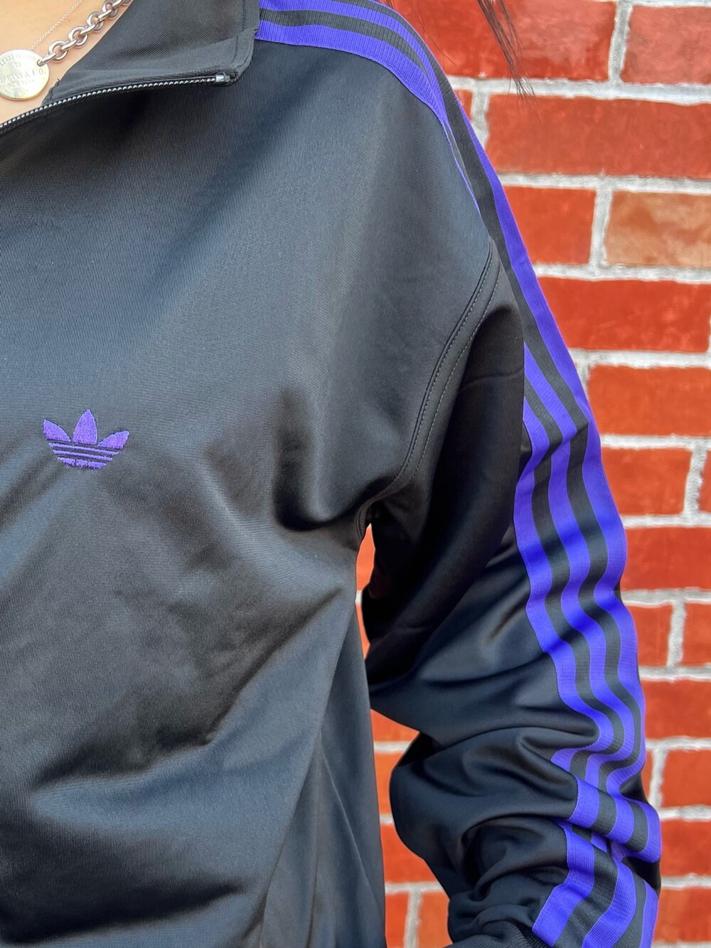 ブラック系のショルダーバッグ、ブラウン系のスニーカー、ブラック系のジャージを着用したレディースの春コーディネートの5枚目の写真