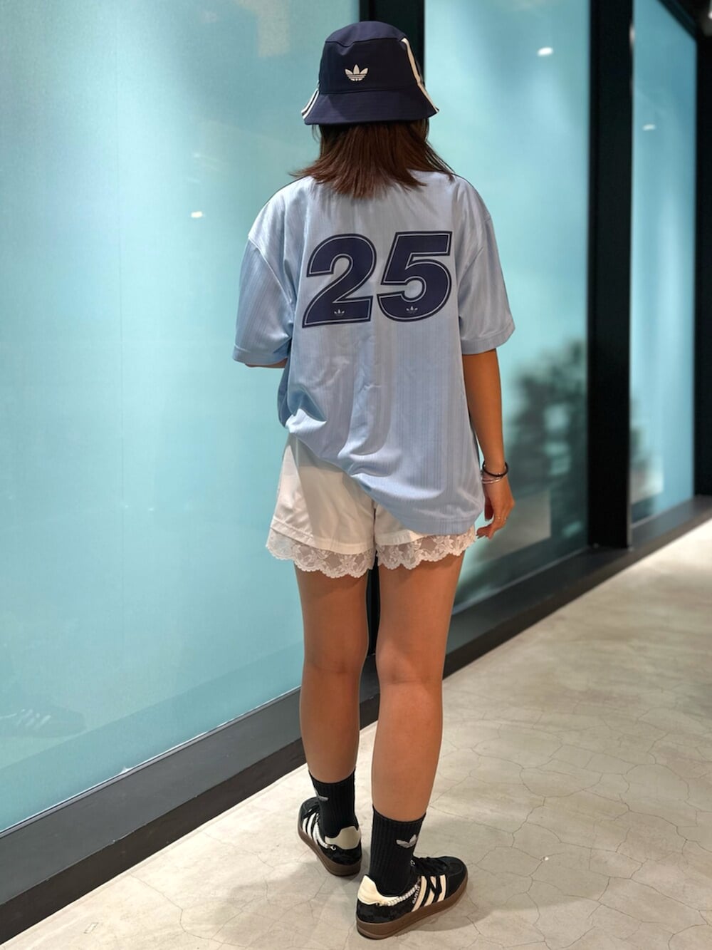 ブラック系のスニーカー、ブルー系のトップス、ホワイト系のその他パンツを着用したレディースの秋コーディネートの3枚目の写真