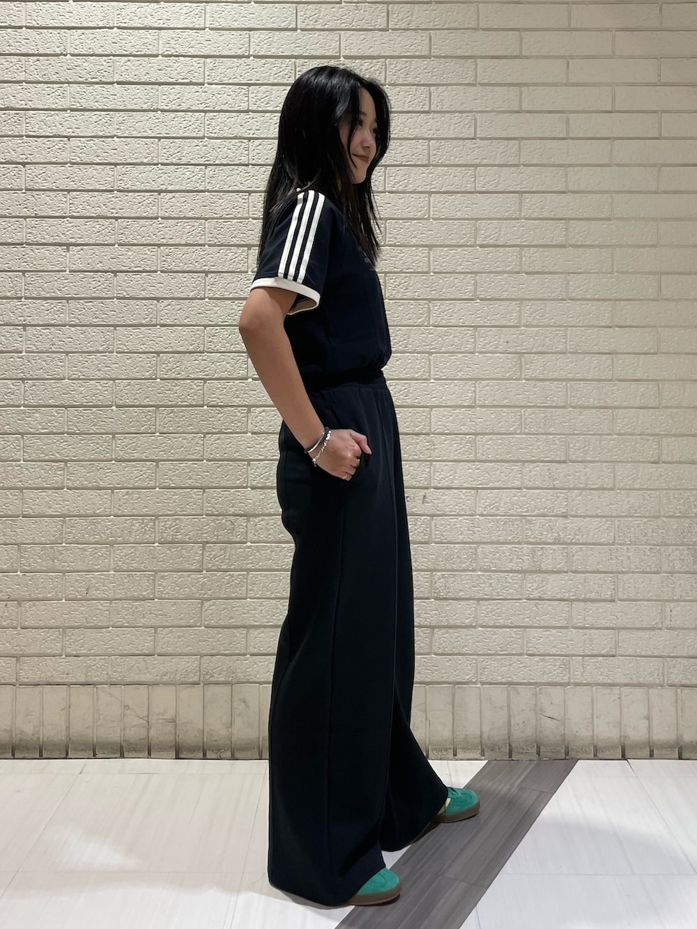 ブラック系のTシャツ/カットソー、ブラック系のその他パンツ、グリーン系のスニーカーを着用したレディースの春コーディネートの3枚目の写真