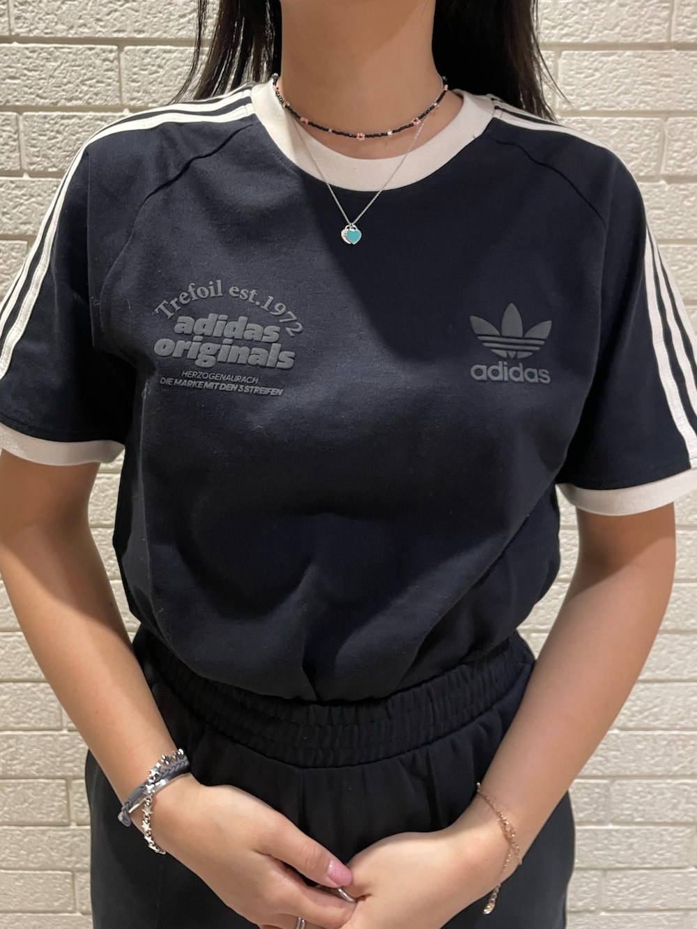 ブラック系のTシャツ/カットソー、ブラック系のその他パンツ、グリーン系のスニーカーを着用したレディースの春コーディネートの4枚目の写真