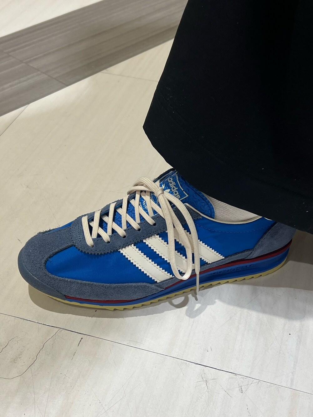 ブラック系のトップス、ブラック系のその他パンツ、ブルー系のスニーカーを着用したレディースの冬コーディネートの4枚目の写真