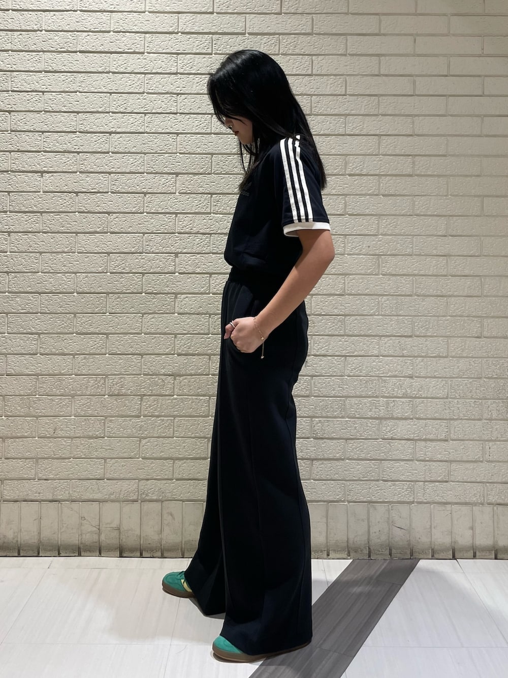 ブラック系のTシャツ/カットソー、ブラック系のその他パンツ、グリーン系のスニーカーを着用したレディースの春コーディネートの2枚目の写真