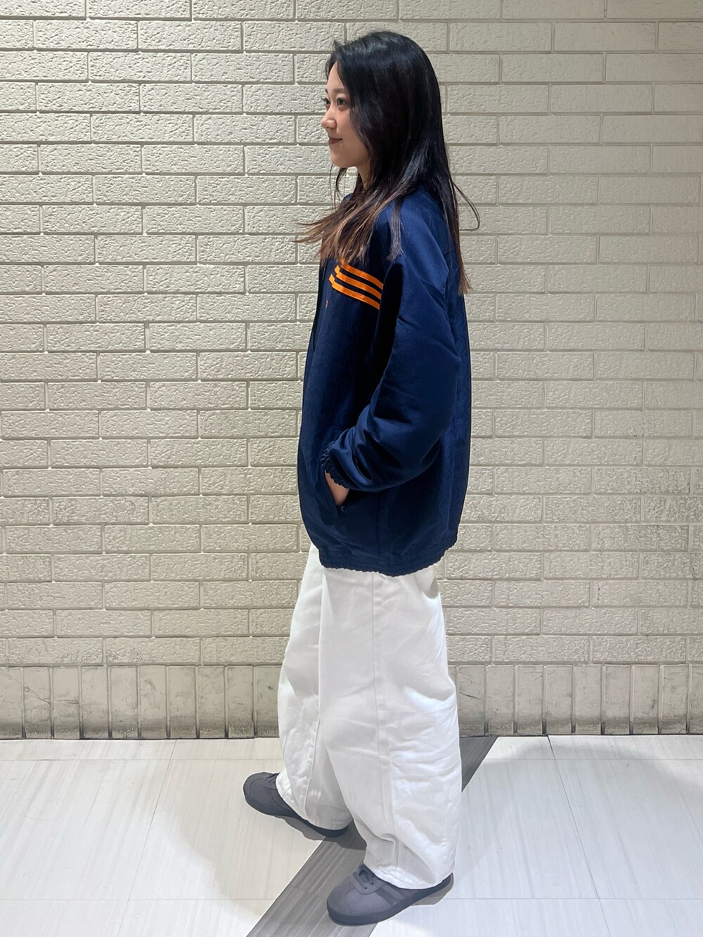 ブルー系のブルゾン、グレー系のシューズを着用したレディースの秋コーディネートの2枚目の写真