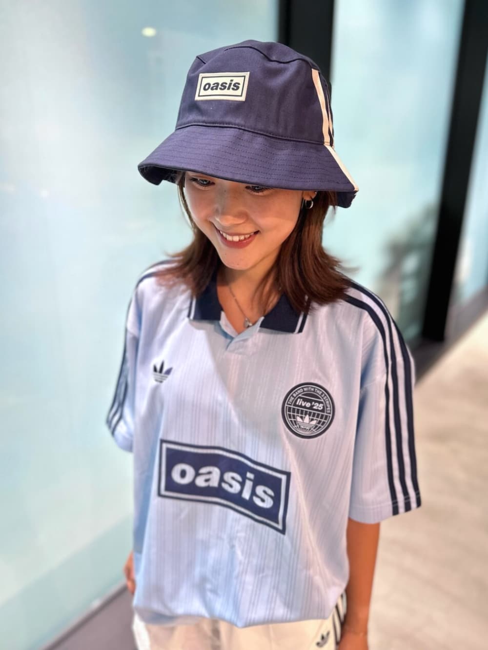 ブラック系のスニーカー、ブルー系のトップス、ホワイト系のその他パンツを着用したレディースの秋コーディネートの4枚目の写真