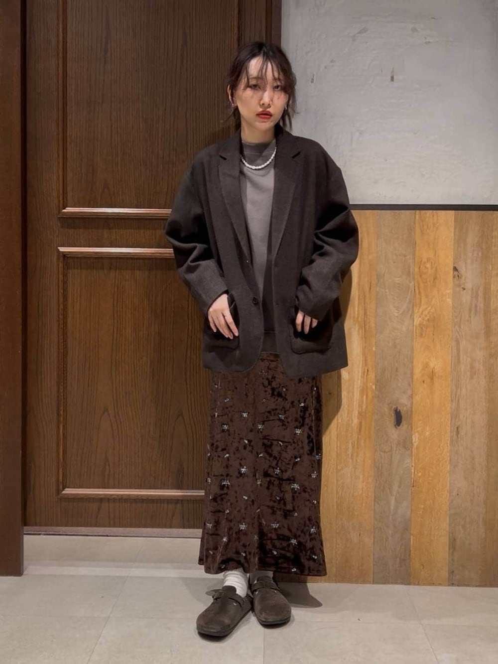 ブラウン系のテーラードジャケット、ブラウン系のスカート、ブラウン系のスウェットを着用したレディースの冬コーディネートの2枚目の写真