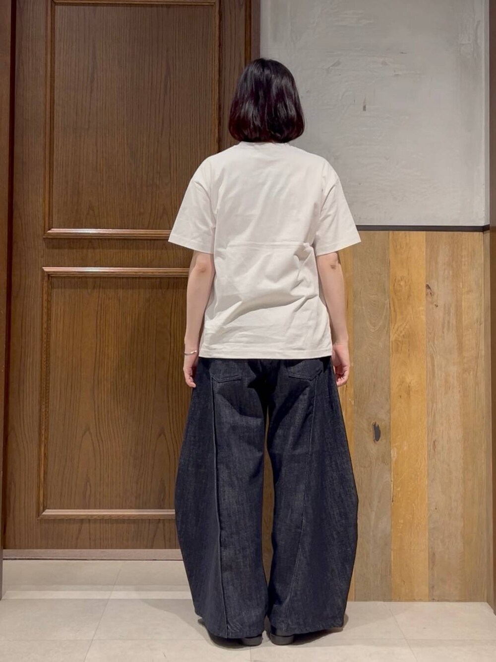 ブルー系のデニムパンツ、ブラック系のキーホルダーを着用したレディースの春コーディネートの6枚目の写真